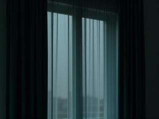 Thick, opaque blackout curtains completely darken a bedroom window